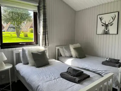 two beds in a room with a deer on the window at Amazing Loch Views in Kilmun