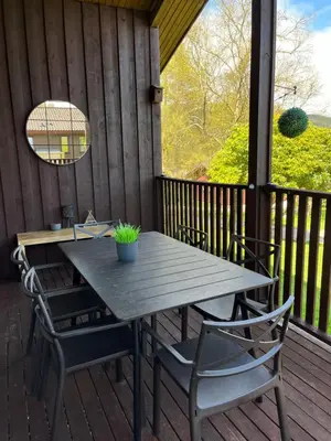 a wooden table and chairs on a deck at Amazing Loch Views in Kilmun