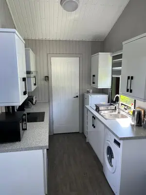 a kitchen with a sink and a washing machine in it at Amazing Loch Views in Kilmun