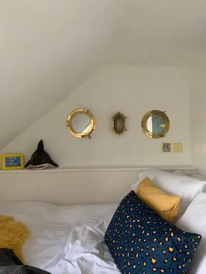 a bedroom with three mirrors on the wall and a bed at This must be the place - Arran, Lamlash in Lamlash