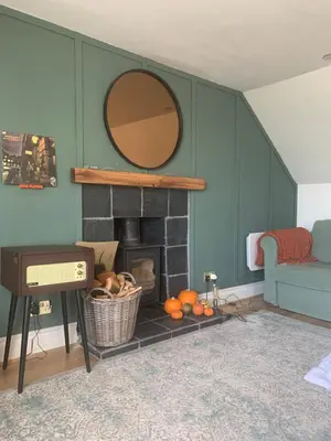 a living room with a fireplace and a mirror at This must be the place - Arran, Lamlash in Lamlash