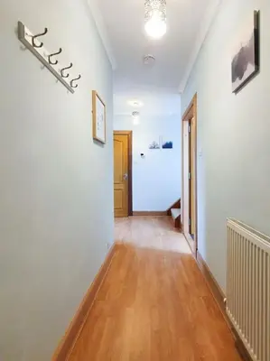 a hallway with white walls and a hard wood floor at Parkgate Apartment - Near M90, Amazon, Edinburgh in Rosyth