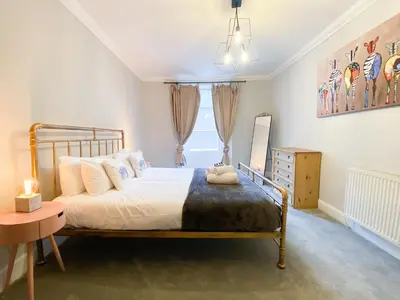 a bedroom with a large bed and a window at Rose Street's Hidden Treasure- 2Bed Newly Refurbished Apt in Edinburgh