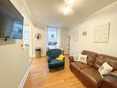 a living room with a couch and a chair at Rose Street's Hidden Treasure- 2Bed Newly Refurbished Apt in Edinburgh