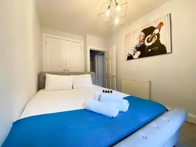 a bedroom with a large bed with a blue blanket at Rose Street's Hidden Treasure- 2Bed Newly Refurbished Apt in Edinburgh