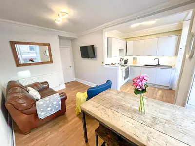 a living room with a couch and a wooden table at Rose Street's Hidden Treasure- 2Bed Newly Refurbished Apt in Edinburgh