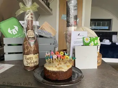 a birthday cake with candles on a table at Raven's Gully - Brodick, Isle Of Arran in Brodick