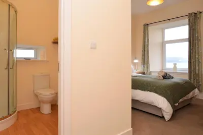 a bedroom with a bed and a toilet and a window at Pedals and Paddles in Innellan