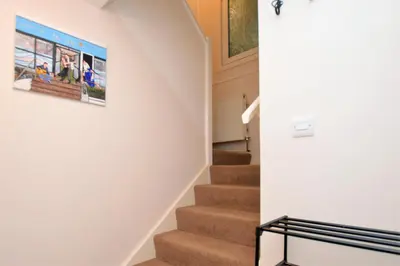 a staircase in a house with a picture on the wall at Pedals and Paddles in Innellan