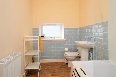 a bathroom with a sink and a toilet and a window at Pedals and Paddles in Innellan