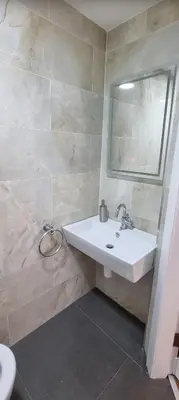 a bathroom with a white sink and a mirror at Laighdykes Guest Cottage in Saltcoats