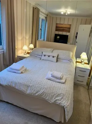 a bedroom with a large white bed with towels on it at Stunning views in Lochgoilhead