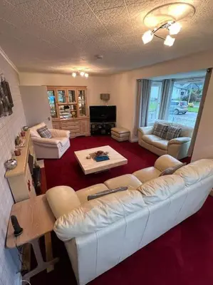 a living room with a white couch and chairs at Stunning views in Lochgoilhead