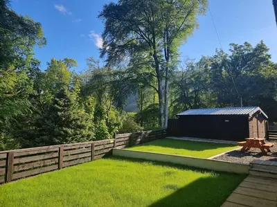 a backyard with a fence and a shed at Stunning views in Lochgoilhead