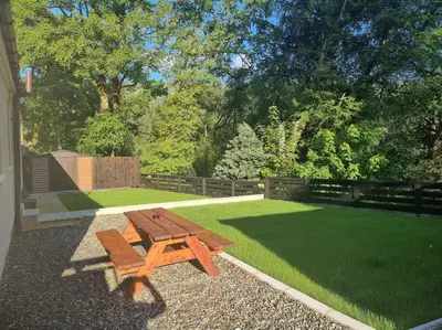 a wooden picnic table in a yard with grass at Stunning views in Lochgoilhead