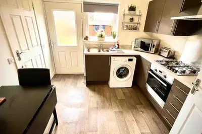 a kitchen with a washing machine and a washer at Loch Leven Getaway - 2 bed house in Kinross