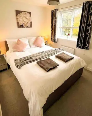a bedroom with a large bed with two towels on it at Loch Leven Getaway - 2 bed house in Kinross