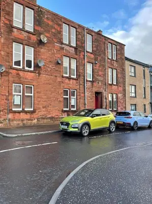 a yellow car parked in front of a brick building at Stevenson Apartment in Alexandria