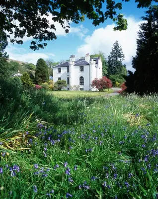 a house in the middle of a field of flowers at Linnhe Apartment, Kinlochlaich House in Appin