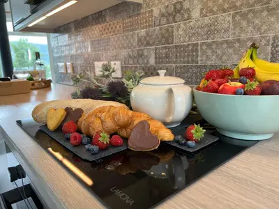a table with a croissant and a bowl of fruit at Ciaran Cottage in Stron-fearnan
