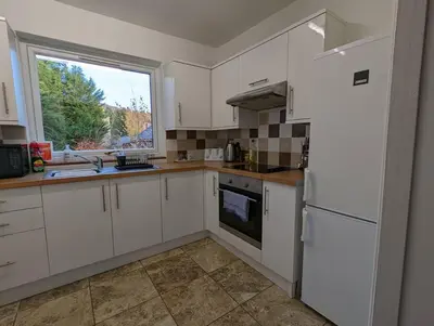 a kitchen with a white refrigerator and a window at Two bedroom flat in Bridge of Allan, Stirling in Bridge of Allan