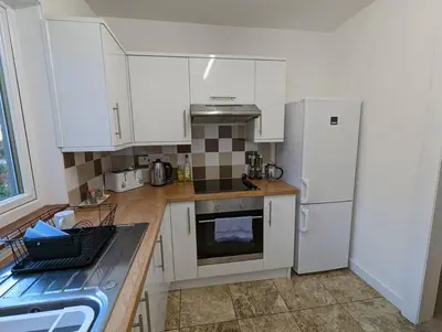 a kitchen with white cabinets and a white refrigerator at Two bedroom flat in Bridge of Allan, Stirling in Bridge of Allan