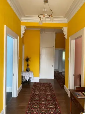 a hallway with yellow walls and a table in a room at St John's Flat Spacious Accomodation in Dalry