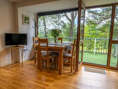 a dining room with a table and chairs and a large window at Ledi - Cottage in Linlithgow