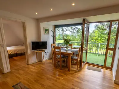 a dining room with a table and chairs and a television at Ledi - Cottage in Linlithgow