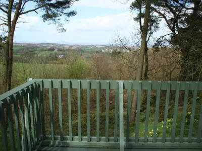 a green bench with a view of a field at Ledi - Cottage in Linlithgow