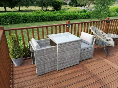 a patio with a chair and a table on a deck at Salmon-Leap Lodge in Dollar