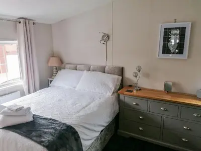 a bedroom with a bed and a dresser at Salmon-Leap Lodge in Dollar