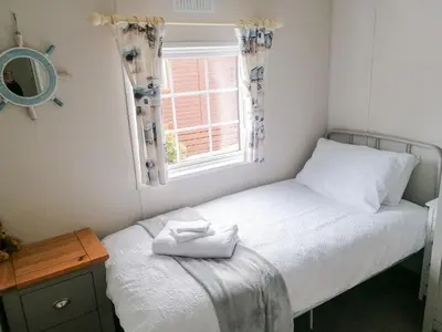 a small bedroom with a bed and a window at Salmon-Leap Lodge in Dollar