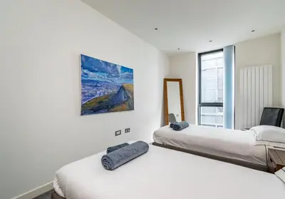 a bedroom with two beds and a painting on the wall at Simpsons Loan - 428 in Edinburgh