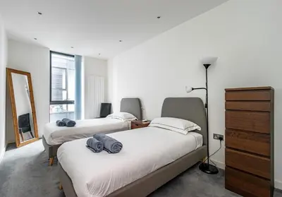 a bedroom with three beds and a dresser and a mirror at Simpsons Loan - 428 in Edinburgh