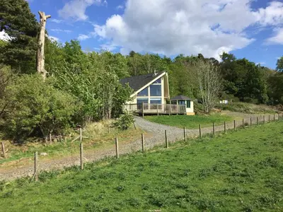 a house on a hill with a fence at Tunturi - Cottage in Linlithgow