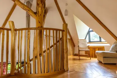 a staircase in a house with a tree in the ceiling at Kinlochlaich Tree House in Appin