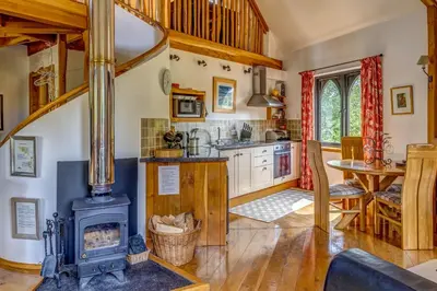 a kitchen with a wood stove in a room at Kinlochlaich Tree House in Appin