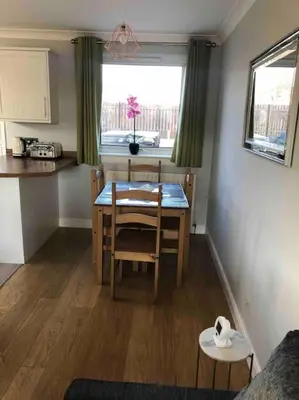 a kitchen and dining room with a table and a window at Cosy Home with Free Parking Near Edinburgh St Andrews M90 & Amazon in Dunfermline