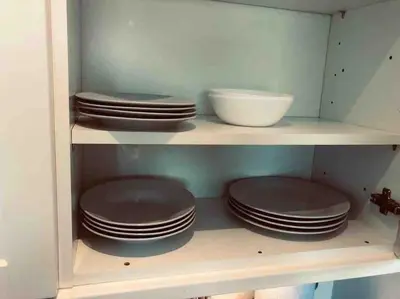 a shelf filled with brown plates and a white bowl at Cosy Home with Free Parking Near Edinburgh St Andrews M90 & Amazon in Dunfermline