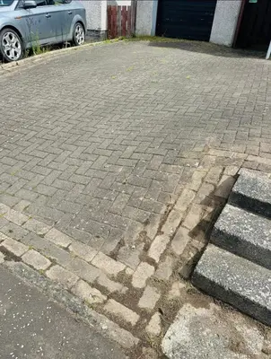a brick parking lot with a shadow on the ground at Cosy Home with Free Parking Near Edinburgh St Andrews M90 & Amazon in Dunfermline