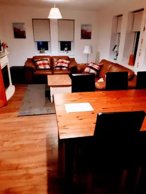 a living room with a couch and a table at Cosy 3 bedroom home in centre of Brodick in Brodick