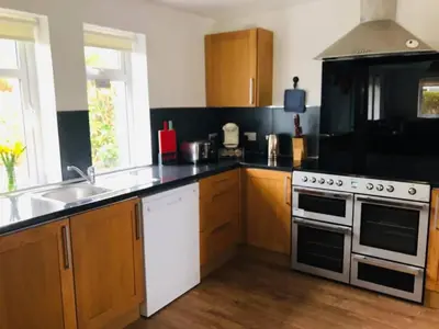 a kitchen with a white stove and a sink at Cosy 3 bedroom home in centre of Brodick in Brodick