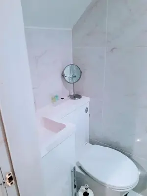 a white bathroom with a toilet and a mirror at Cosy 3 bedroom home in centre of Brodick in Brodick