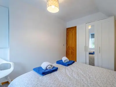 a bedroom with a bed with blue towels on it at Cosy 3 bedroom home in centre of Brodick in Brodick