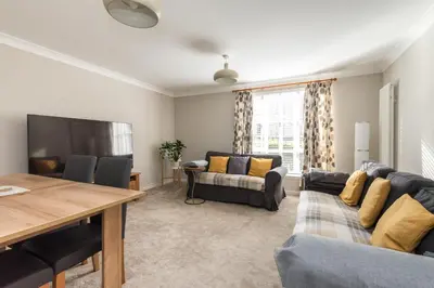a living room with a couch and a table at Cosy Roseburn Apartment, Edinburgh - 2 Bedrooms, FREE PARKING in Edinburgh