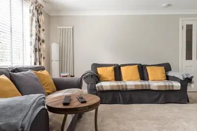 a living room with a couch and a table at Cosy Roseburn Apartment, Edinburgh - 2 Bedrooms, FREE PARKING in Edinburgh