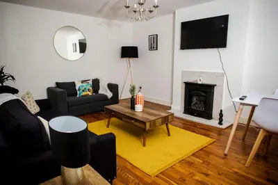 a living room with a couch and a fireplace at Tower Square House in Alloa