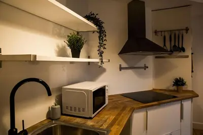a kitchen with a sink and a microwave on a counter at Tower Square House in Alloa