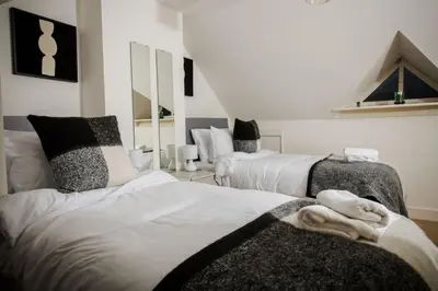 a bedroom with two beds with towels on them at Tower Square House in Alloa